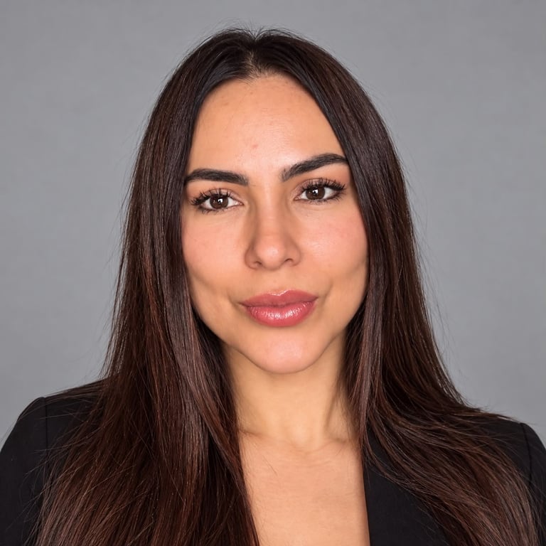 Headshot of Alejandra with long dark brown hair, defined eyebrows, and pink lipstick against a gray background